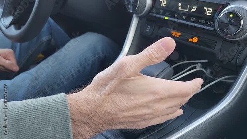 Male hand moves the transmission selector lever to reverse gear. The scene focuses on driver control, vehicle operation, and interior detail of a modern automobile.