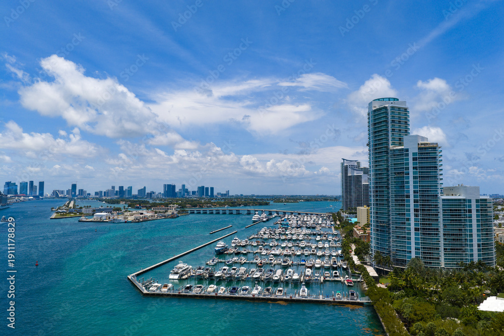 Obraz premium Luxury yacht docked at Miami marina. Aerial view of coastline in Miami. Sailboat cruising along the Miami shore.