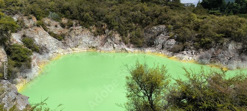 a green lake surrounded by trees and rocks
