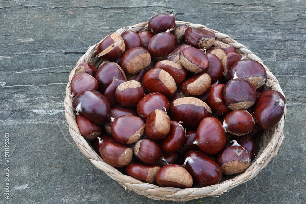 Obraz premium Chestnuts in wicker basket from autumn harvest