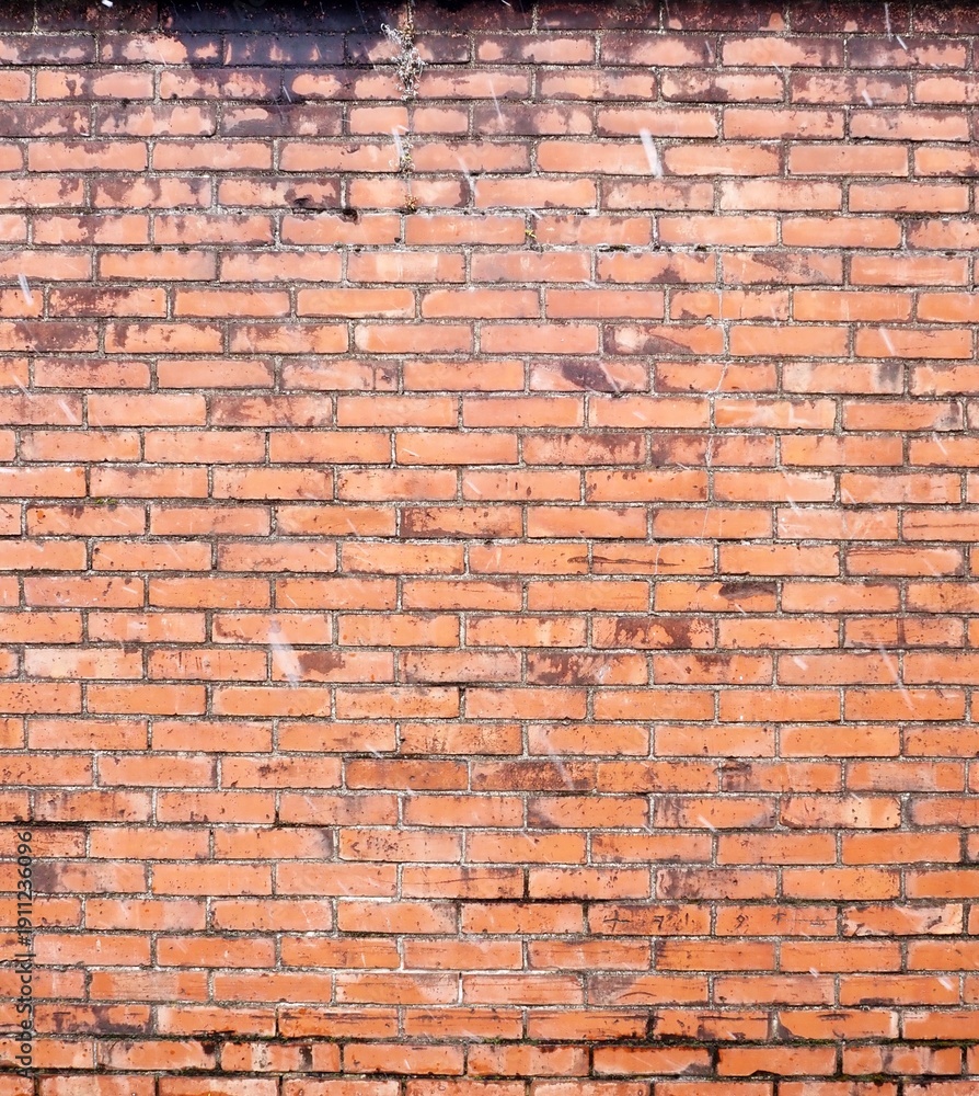 Obraz premium Weathered Brick Wall with Light Snowfall Background