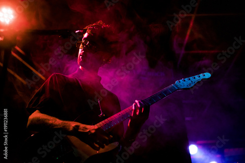 Foto a contraluz de un participante de una banda de música con efectos de luces