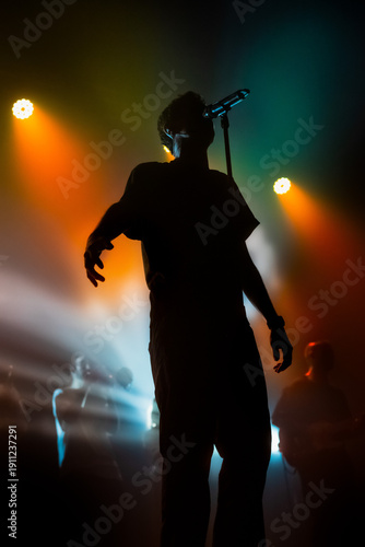 Foto a contraluz de un participante de una banda de música con efectos de luces