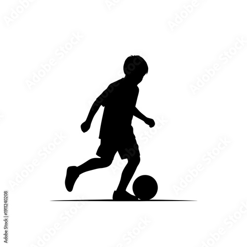 Silhouette of a young boy playing soccer with a ball, depicting childhood activity and sports