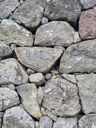 Traditional grey fieldstone wall masonry