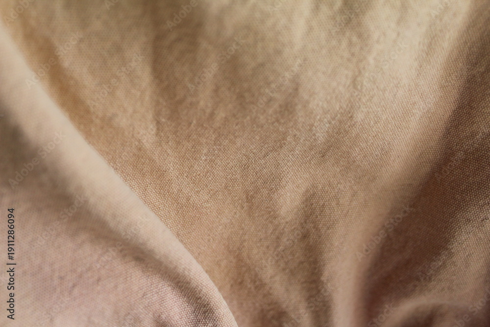 Naklejka premium beige cotton fabric texture.soft folds and wrinkles, neutral textile background, abstract cloth surface.for backdrop, mockup, wallpaper, and design, cover