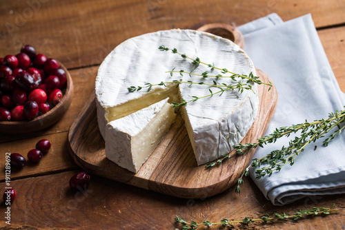 Bild auf Leinwand Camembert or brie cheese served on a rustic wooden table, natural light, artisanal food styling and simple composition
