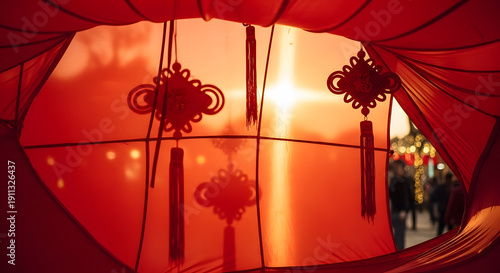 Vibrant red Chinese lanterns with traditional decorative knots, illuminated by a warm sunbeam, framing a festive outdoor scene during a cultural celebration