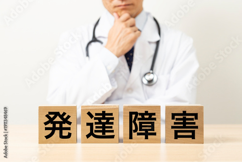 「発達障害」と書かれたブロックと悩む医師