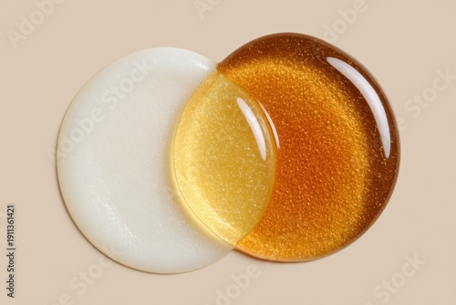 Two glossy liquid circles, one pearly white and one golden, overlap on a neutral surface, suggesting premium serums or oils ideal for modern skincare and beauty branding.