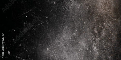 A heavily scratched and wall textured black surface with subtle light variations and imperfections visible throughout the frame