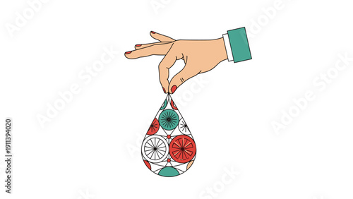 Human hand delicately holds a teardrop shaped ornament decorated with colorful abstract patterns and geometric shapes in a creative display.