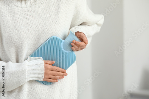 Woman warming her stomach w...