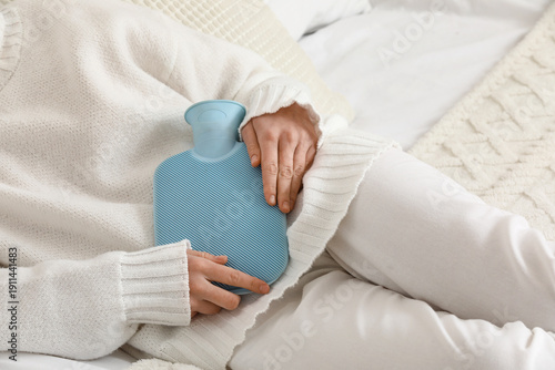 Woman warming her belly wit...