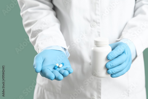 Doctor holding pills on blu...