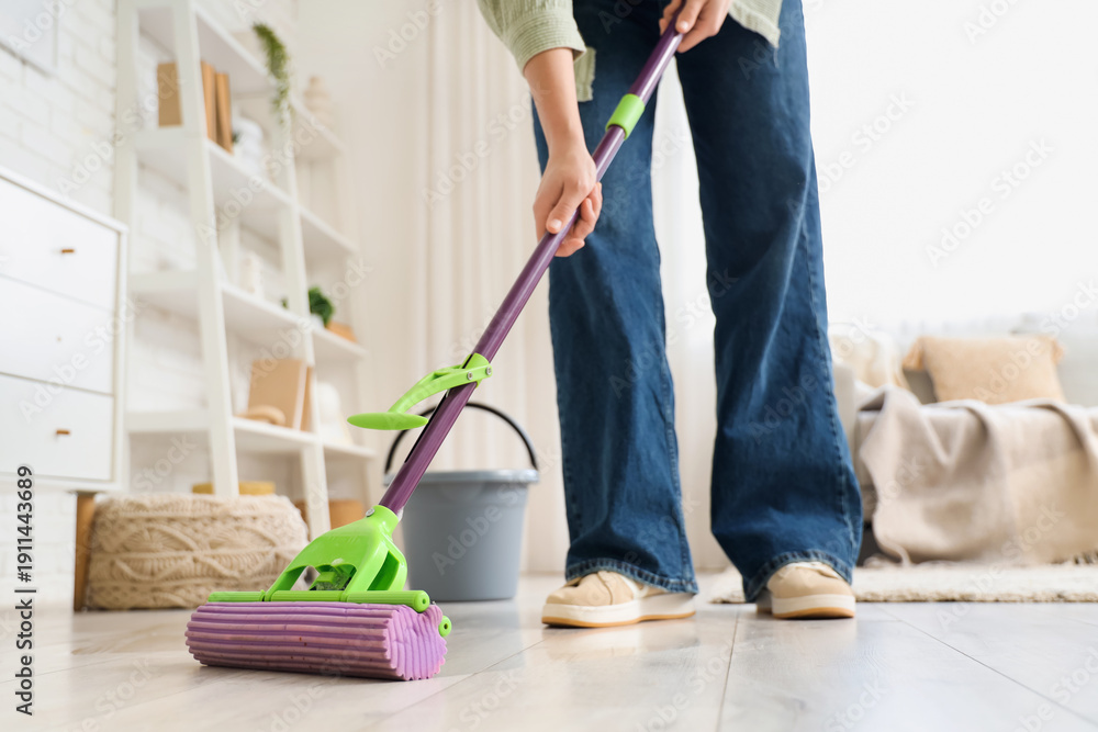 Fototapeta premium Woman mopping floor in room