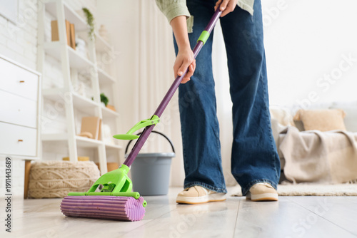 Woman mopping floor in room