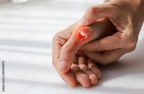 Foto Close up of woman massaging painful thumb with anatomical joint illustration and red highlight