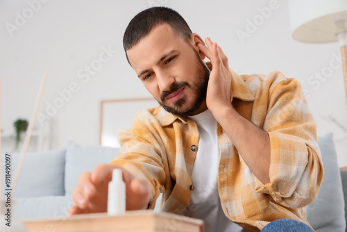 Young man with ear pain tak...