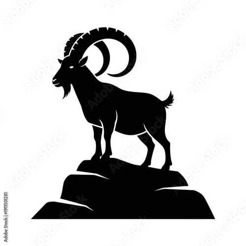 Silhouette of a majestic ibex standing on a rocky outcrop