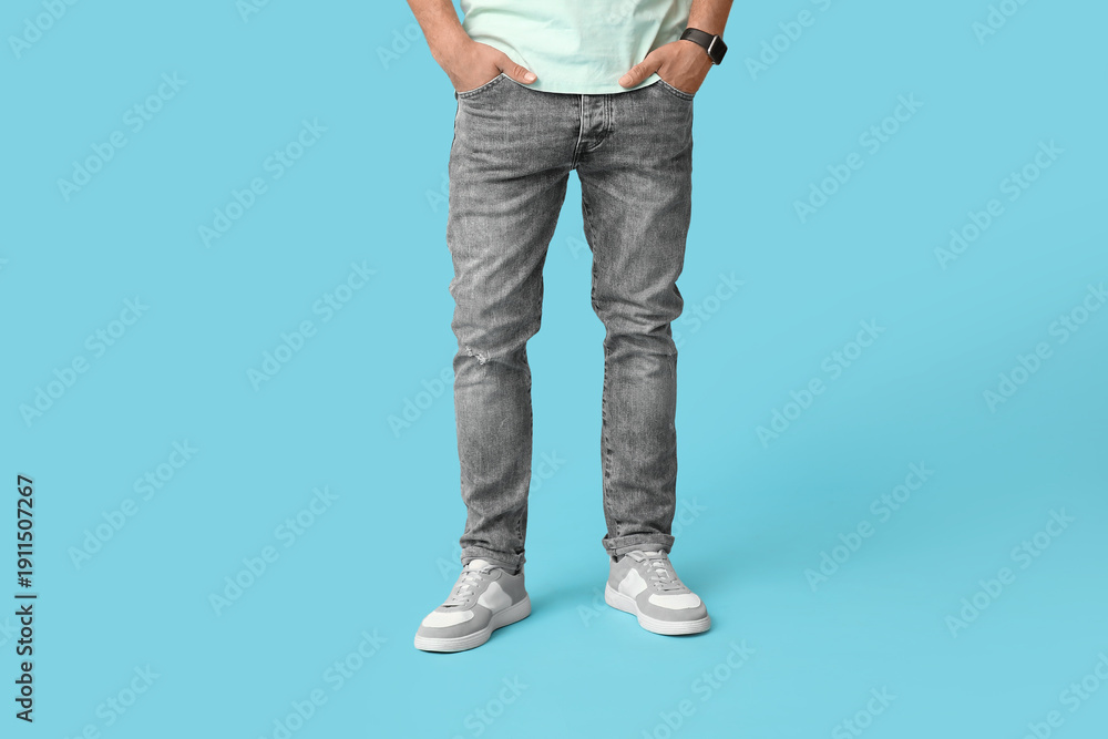 Naklejka premium Stylish man in jeans on blue background