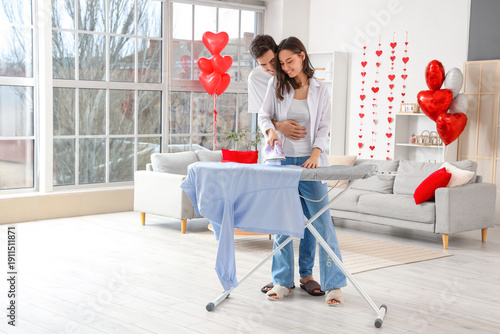 Happy young couple ironing ...