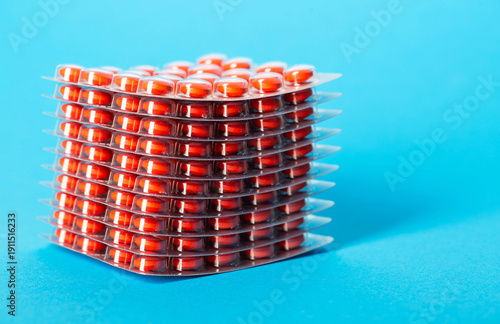 Stack of chondroprotector tablets on a blue background. Glucosamine and chondroitin for joints. Copy space for text, anti-inflammatory