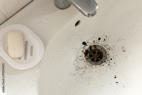 Tableau sur toile Dirty bathroom sink with a clogged drain and dark grimy debris
