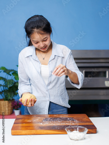 Εκτύπωση καμβά Asian woman bakers sprinkling dough with flour on wooden cutting board preparing