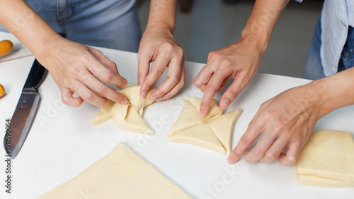 Closeup hand of woman bakers chef shaping folding puff pastry dough pie on white table process making workflow ingredients flour delicious homemade sweet dessert bread baking cooking in bakery kitchen