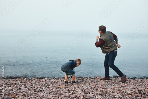 Obraz na płótnie Dad, child and throw rock by river with connection, game and bonding together on weekend break