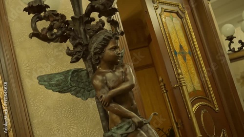 Statue of a little angel in a European hotel. Bronze statue of a child angel with wings.