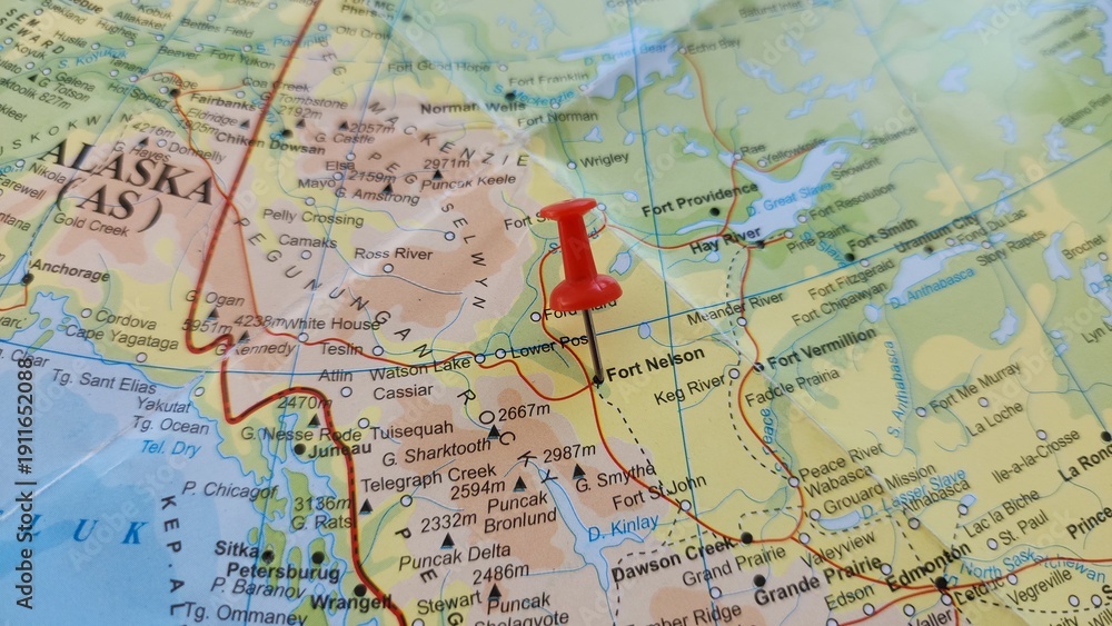 Fototapeta premium View of Fort Nelson, Human settlement in British Columbia, Canada, on a geographical map of America, marked with red push pin