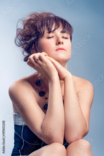 Portrait of Winsome Sexy Sensual Caucasian Woman With Bright Makeup Curly Hairdo Posing Over Color Background As Concept of Cosmetics, Makeup and Rejuvenation