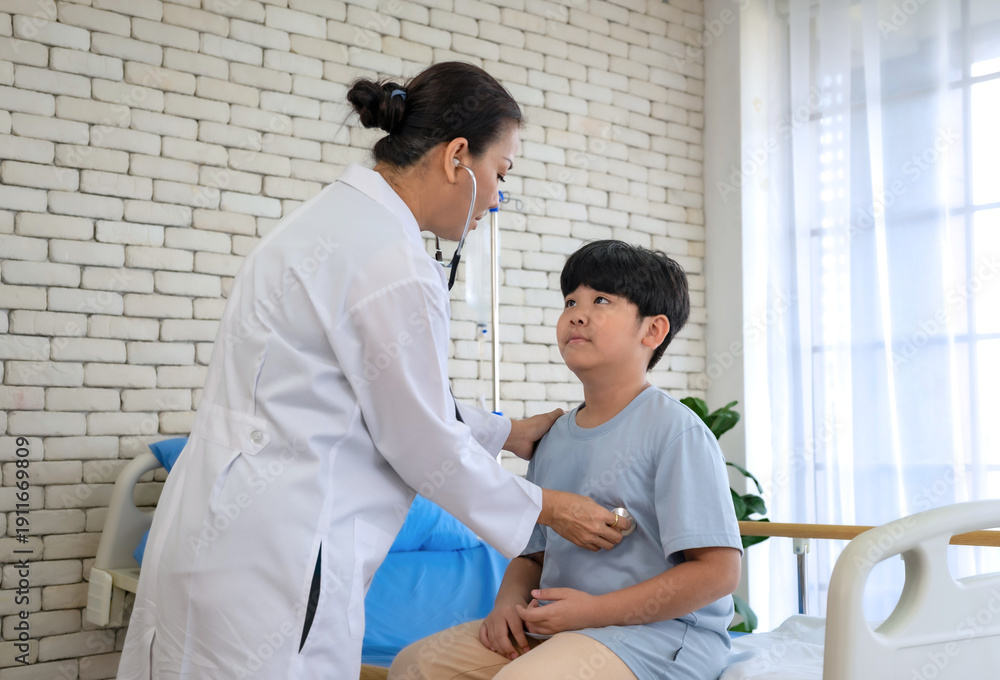 Fototapeta premium Pediatrician examining child patient. Young woman doctor puts stethoscope to little chest and checks.health care and medical concept