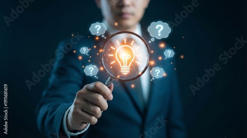 A businessman in a suit holds a magnifying glass that illuminates a bright glowing lightbulb, surrounded by many floating question marks, representing the pursuit of creative solutions and answers.