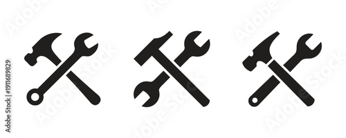 Set of black silhouettes of hammer and wrench crossed tools