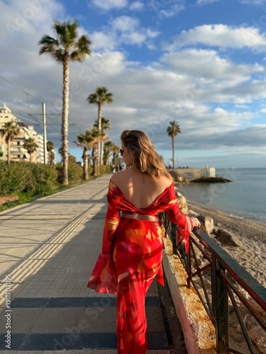 young woman in red dress on the beach