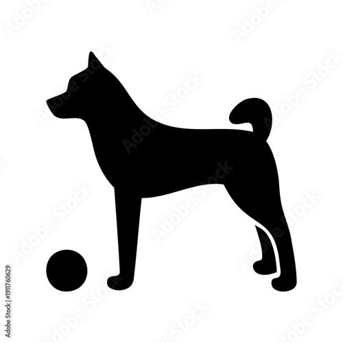 Elegant black silhouette of a Shiba Inu dog standing near a ball