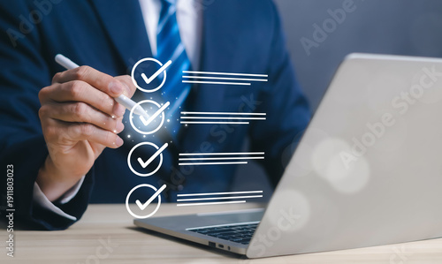 Foto Checklist and quality control concept with businessman marking approved tasks on virtual interface near laptop
