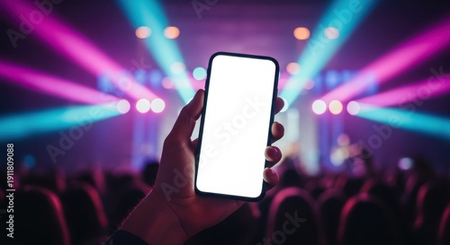 Hand holding blank screen smartphone at vibrant concert with colorful stage lights and crowd