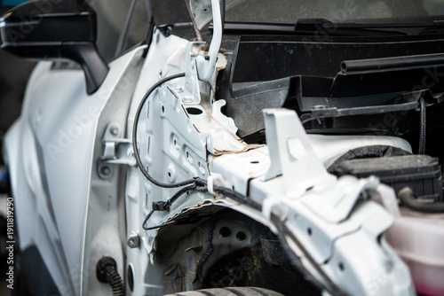 Closeup of damaged white car frame inside an auto body shop