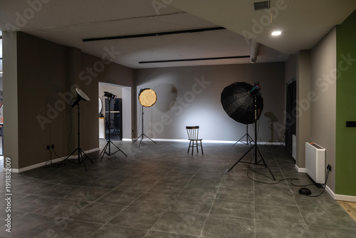 Interior of a professional photography studio with professional lighting equipment, softboxes and tripods.