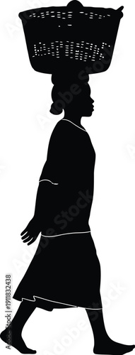 Woman carrying a large wicker basket on her head while walking alone outdoors