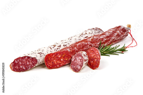 Dry cured sausages of different varieties and colors, with rosemary garnish, isolated on white background