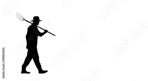 Silhouette of a man carrying a pitchfork and walking in the countryside