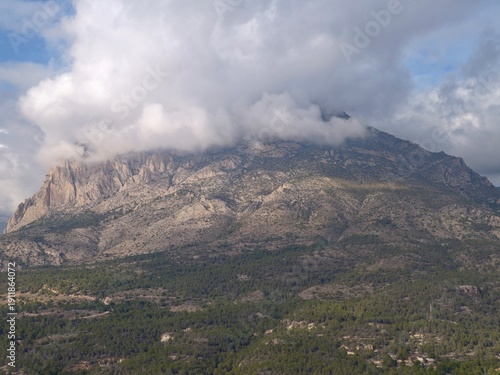 Bild auf Leinwand Majestic mountain scene, Vast mountain summit surrounded by swirling low clouds
