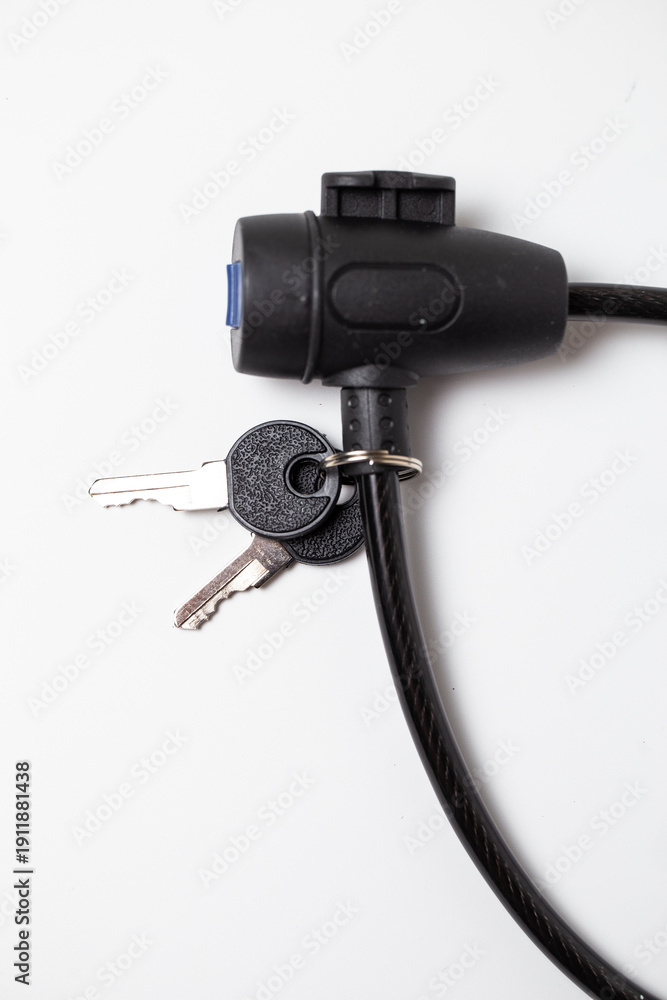 Fototapeta premium Close-up of black cable lock with attached keys on white background