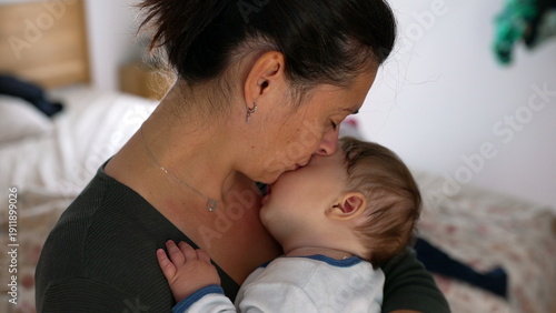 Mother holding her baby close, both with their eyes closed, embracing a quiet moment of tenderness and love in a nurturing home environment
