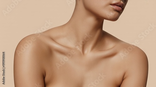 Flawless smooth tanned skin of a young woman's neck, elegant collarbones, bare shoulders, and delicate chin shown in a close up studio view highlighting natural beauty and body care